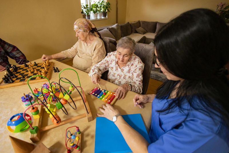 Group of seniors smile as they challenge each other in memory games with toys and chess.