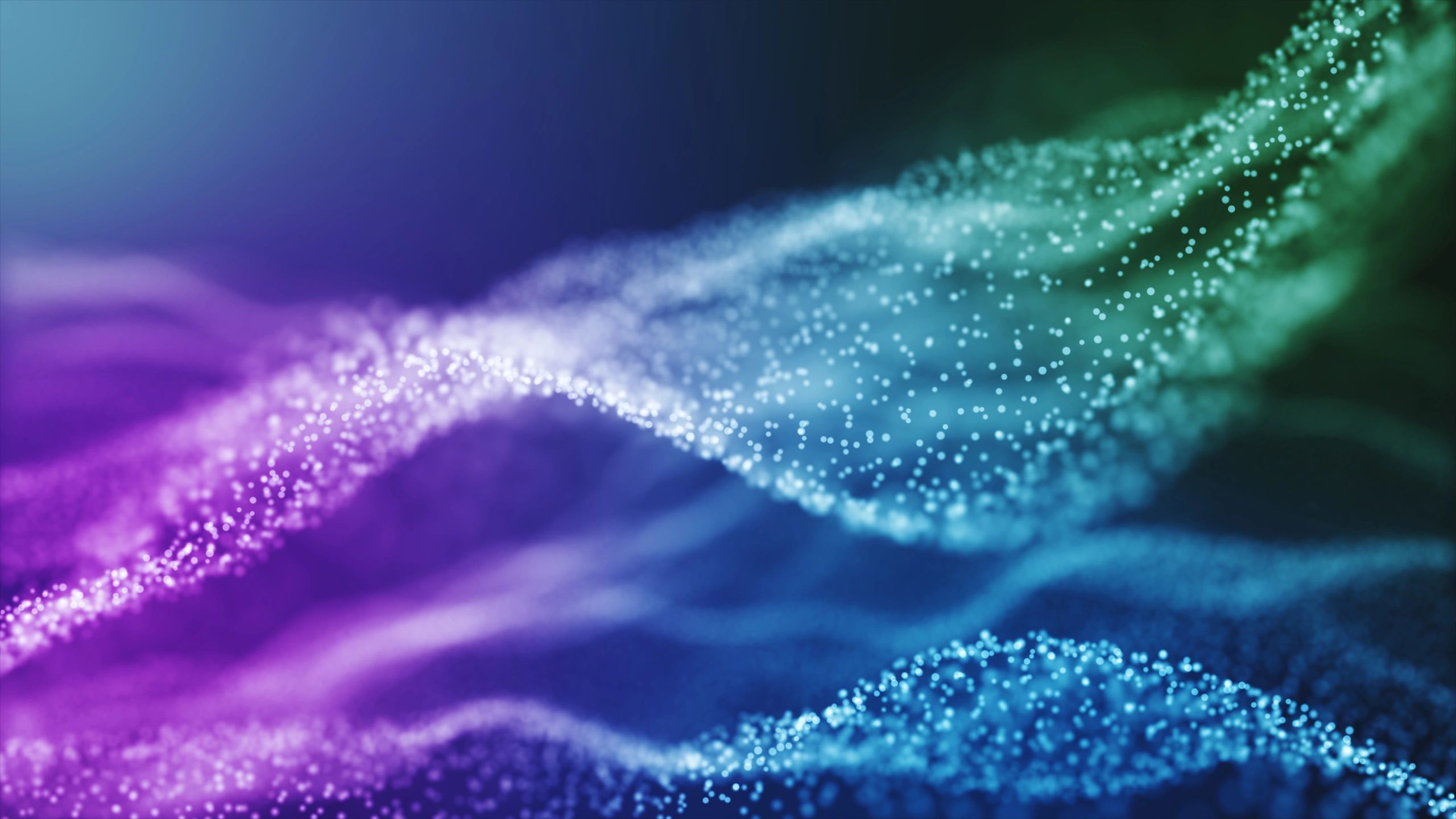 Colorful wave of glowing particles forming an abstract digital landscape.