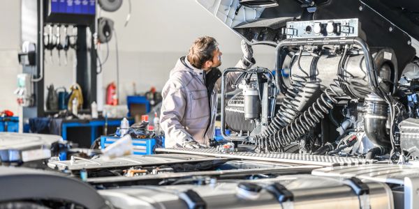 Mechanic inspecting truck engine.