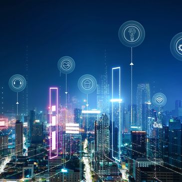 Futuristic cityscape at night with digital technology icons floating above buildings.