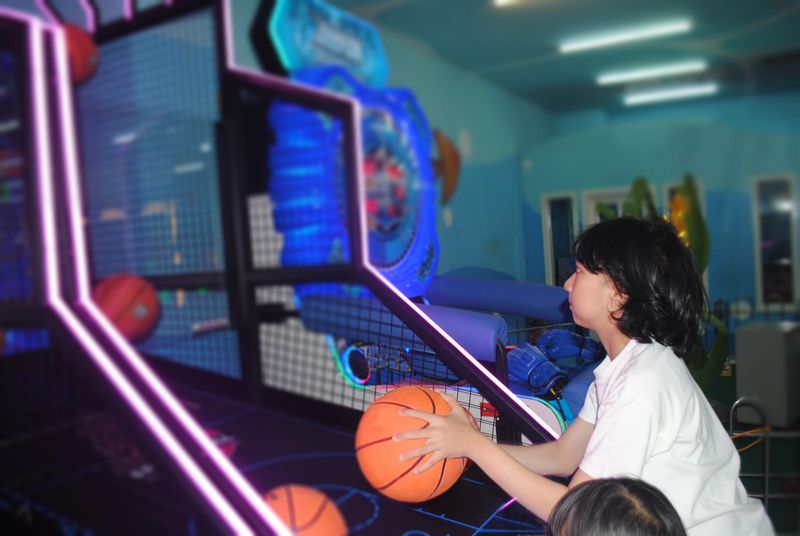 Asian teenage girl is playing in arcade games.