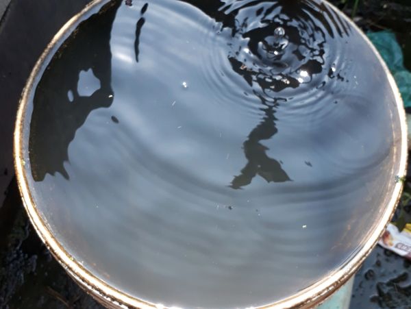 Water ripples in a round container outdoors.