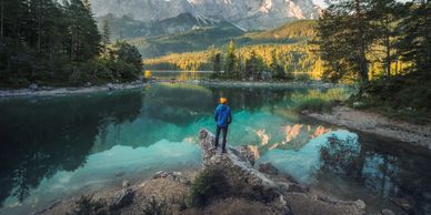 A person standing on the shore of a lake