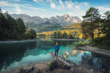 A person standing on the shore of a lake