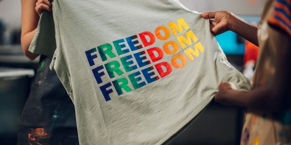 A t-shirt displaying the word 'FREEDOM' in colorful, repeated letters.