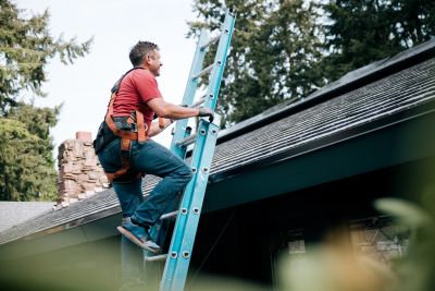 Man climbing ladder to roof.