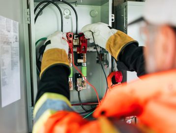 Electrician working on a circuit breaker panel.