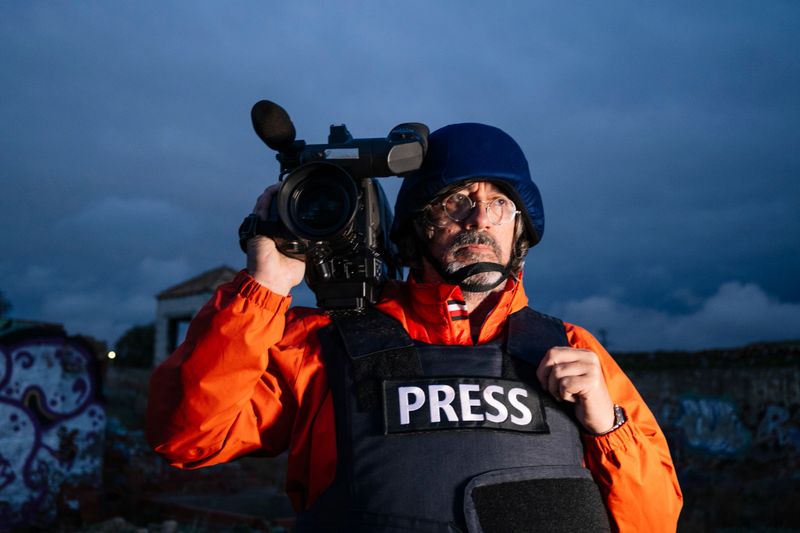 Reporter in bulletproof vest holding a video camera