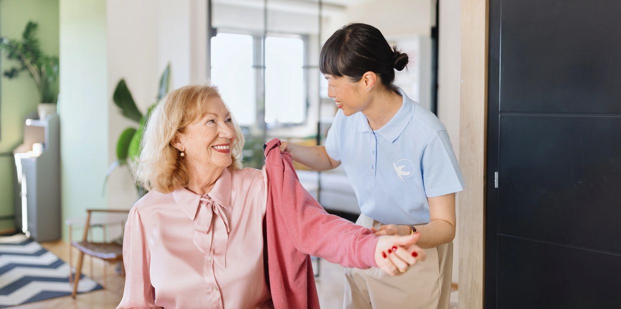 young healthcare worker serving meal to older man