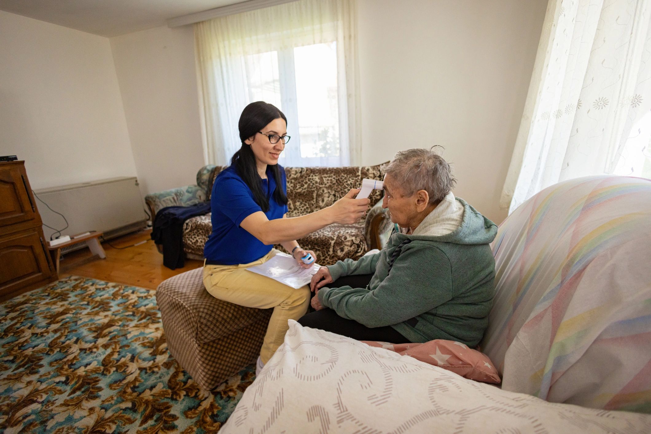 Home health nurse taking blood pressure