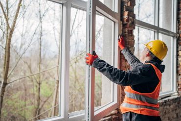 Construction worker installing a window frame.