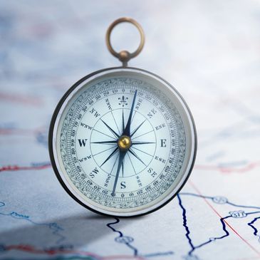 Vintage compass on a detailed map, symbolizing navigation and direction.