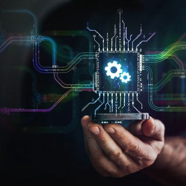 Hand holding a digital microchip with glowing gears and circuit lines.