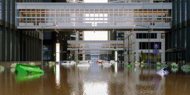 Street flooded with water and submerged vehicles.