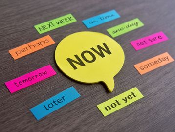 Colorful sticky notes with time-related words around a central note saying NOW.