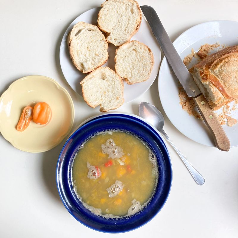 High angle view of fresh vegan soup made at home with slice of bread over table in the kitchen for lunch