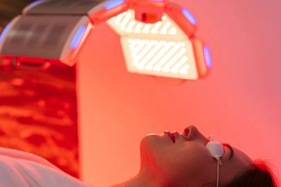 Person undergoing a red light therapy session wearing protective goggles.