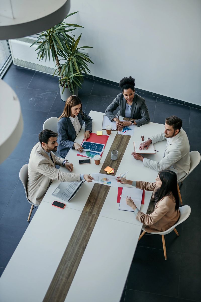 High angle view of diverse business people discussing together while having a meeting around a table in a modern office