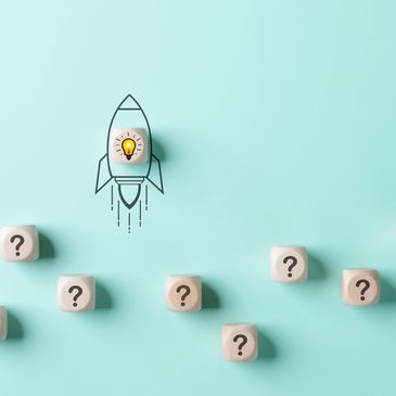 Dice with question marks are at the bottom of the image and a rocket with a lightbulb shoots upward.