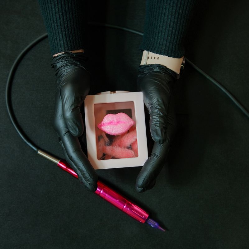tool for permanent makeup in hands in black gloves. Against the background of a beautiful box