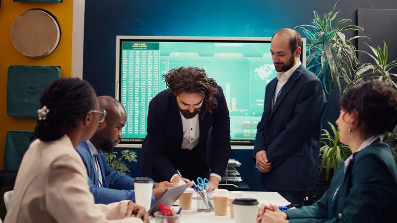 Business administrators shaking hands and signing a new contract, starting fruitful collaboration between their enterprises. Leaders agreeing to terms, organizational growth and success. Camera B.