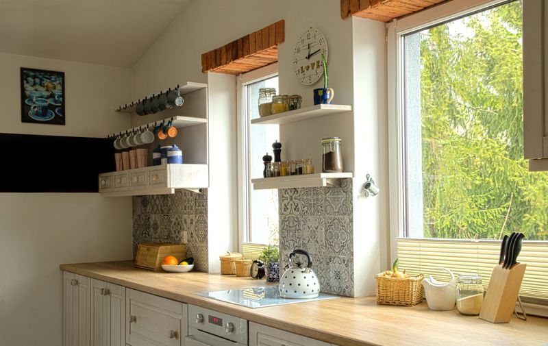 Home interior in a cottage in rustic design with white furniture and decoration of kitchen utensil