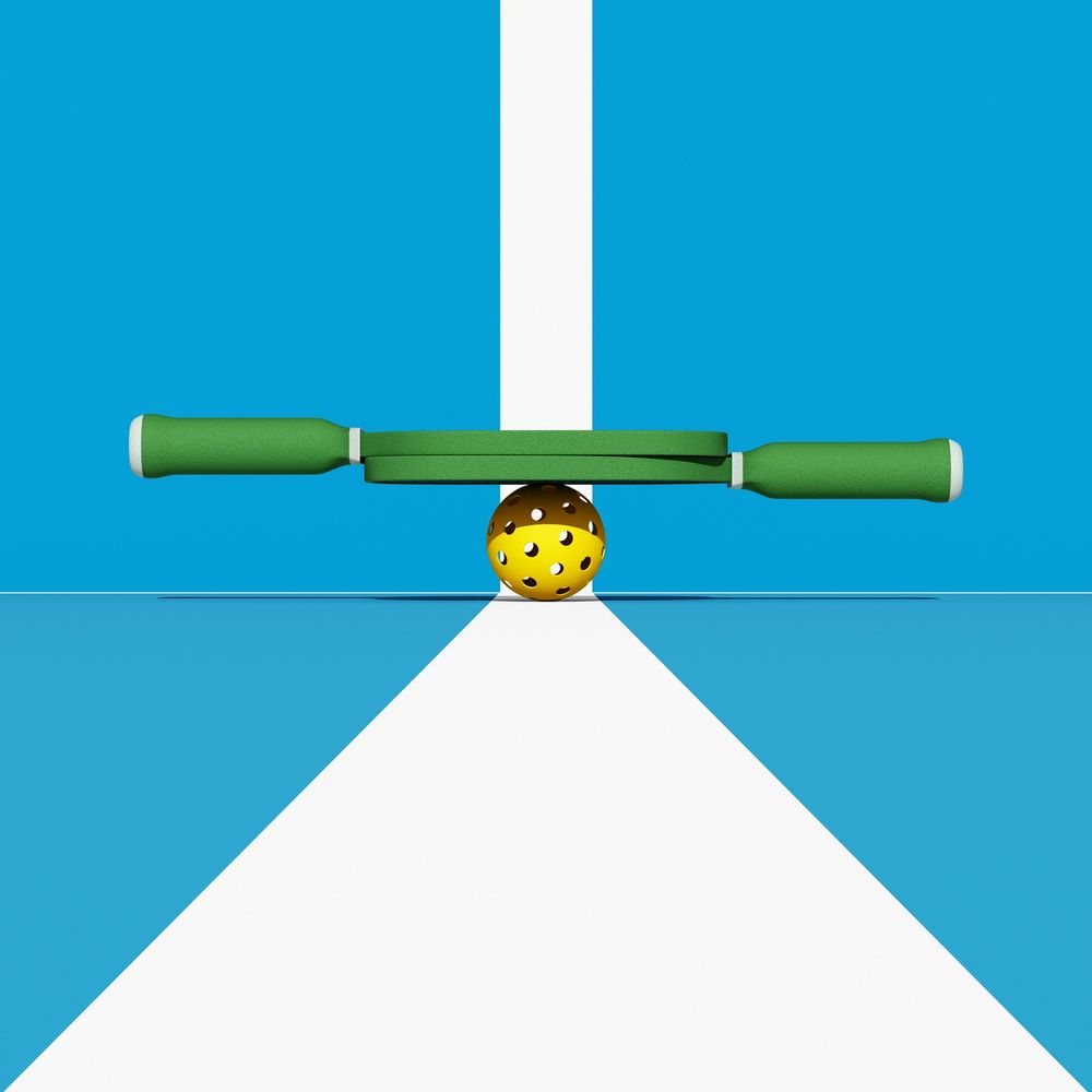 Pickleball paddle and perforated ball on a blue court with white lines.