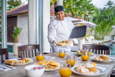 Waiter holding an empty silver tray.
