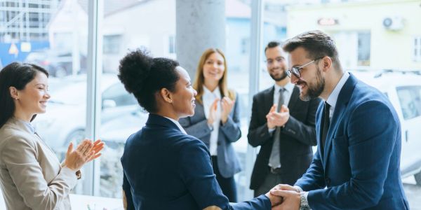 Colleagues congratulating each other in an office.