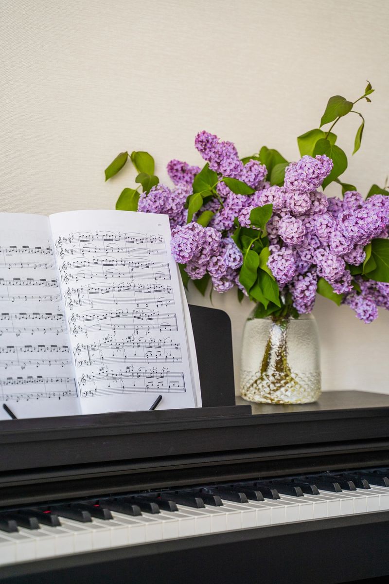 a bouquet of lilacs in a transparent jar and musical notes stand on the piano