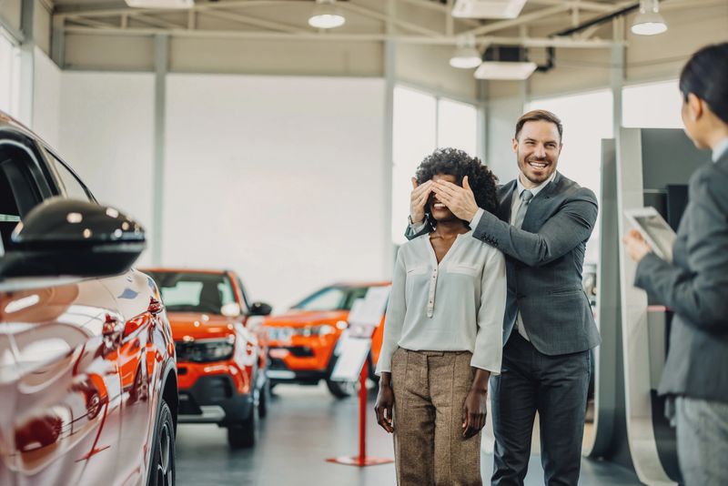 A personalized car buying journey unfolds in the showroom, with a female seller dedicating her attention to understanding and meeting the unique needs of a multiracial couple