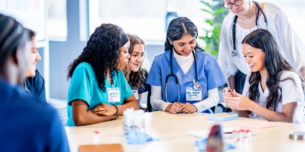 Medical team discussing patient care around a table in a bright room.
