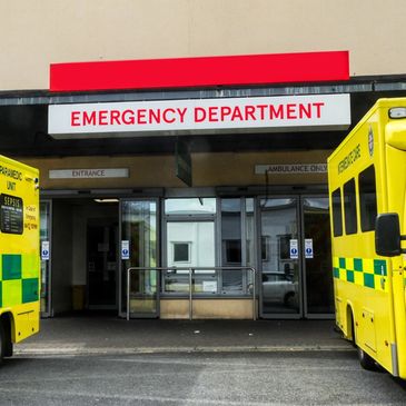 Two ambulances parked at a hospital ER entrance, symbolizing emergency mobile services.