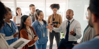 Doctor leading a team meeting in a hospital.