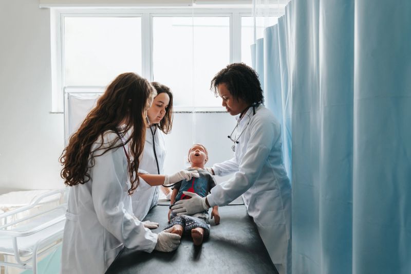 Medical students in practical class with doll in the ward