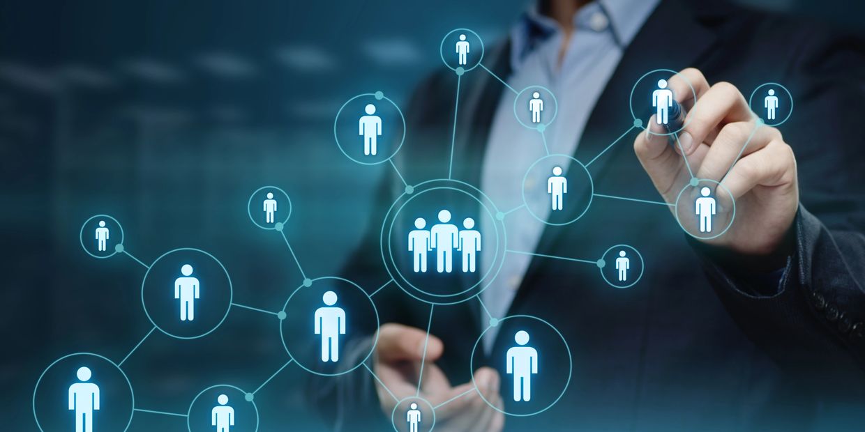 Businessman interacting with a digital network of connected people icons.