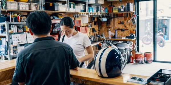 Two people in a motorcycle repair shop.