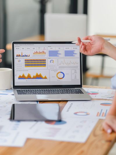 Laptop screen showing a sales opportunity dashboard with charts and graphs.