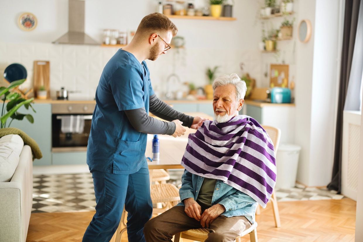 Caregiver serving breakfast to elderly man in a cozy living room  in Odenton Maryland 