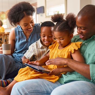 Happy family enjoying time together using a tablet at home.