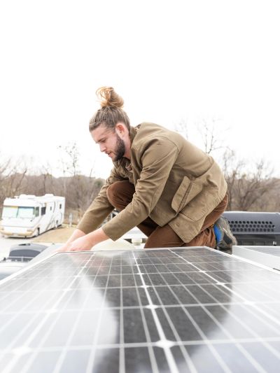 Man installing solar panels on a rooftop.
