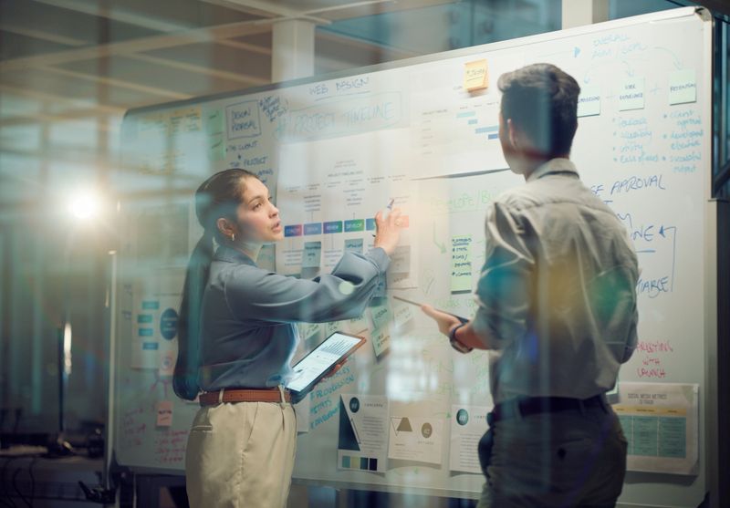 Window, teamwork and whiteboard for brainstorming in meeting, business people with tablet and digital notes with agenda storyboard. Information, people with research and calendar for project schedule