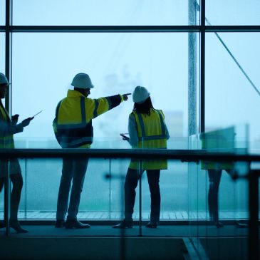 Construction workers discussing plans inside a building.