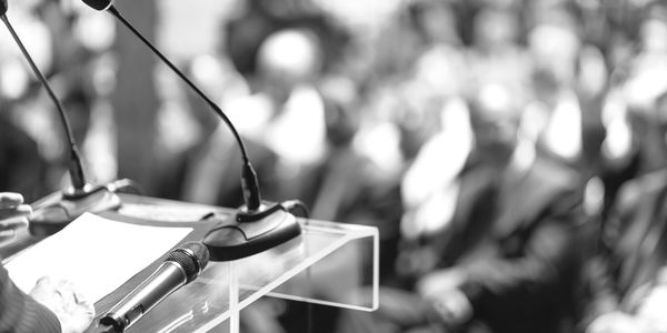 a podium and microphone with an audience in background
