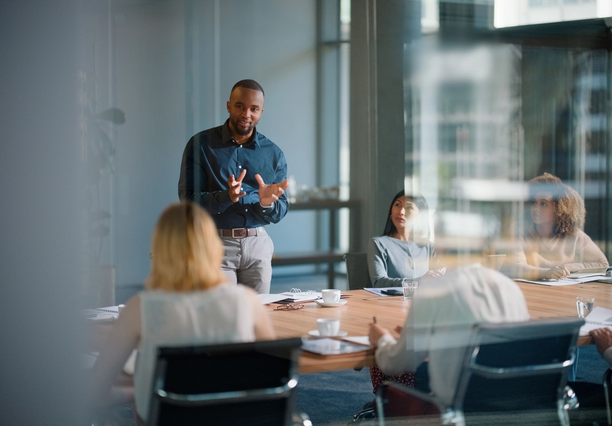 Man presenting to colleagues in a meeting room.