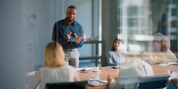 Man presenting to colleagues in a modern office.