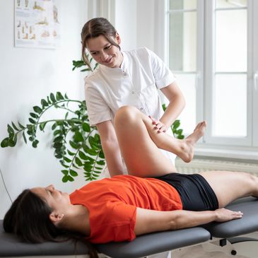 Physiotherapist assisting a patient with leg exercises.