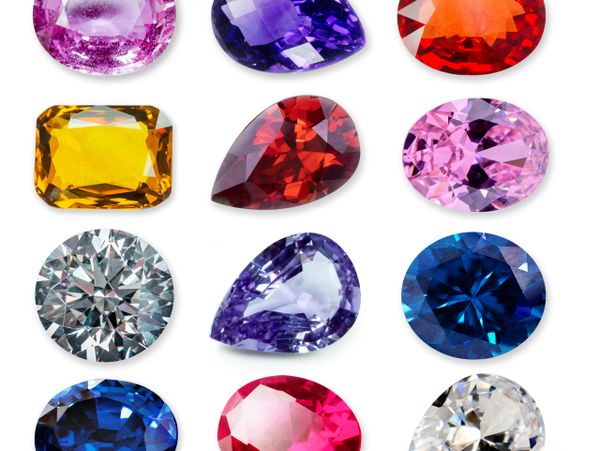 A collection of various colorful cut gemstones on a white background.