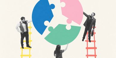 Three people assembling a large circular puzzle with colored pieces.