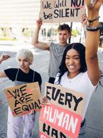 Protesters holding equality and human rights signs.